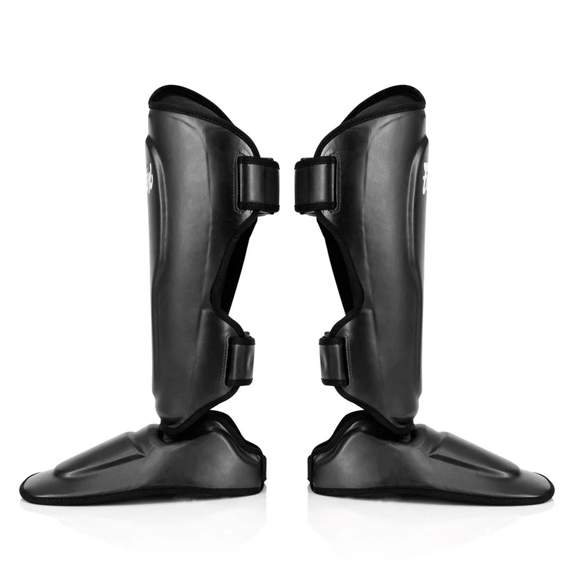 Professional Fairtex MMA and kickboxing shin protectors with extended side and toe coverage.