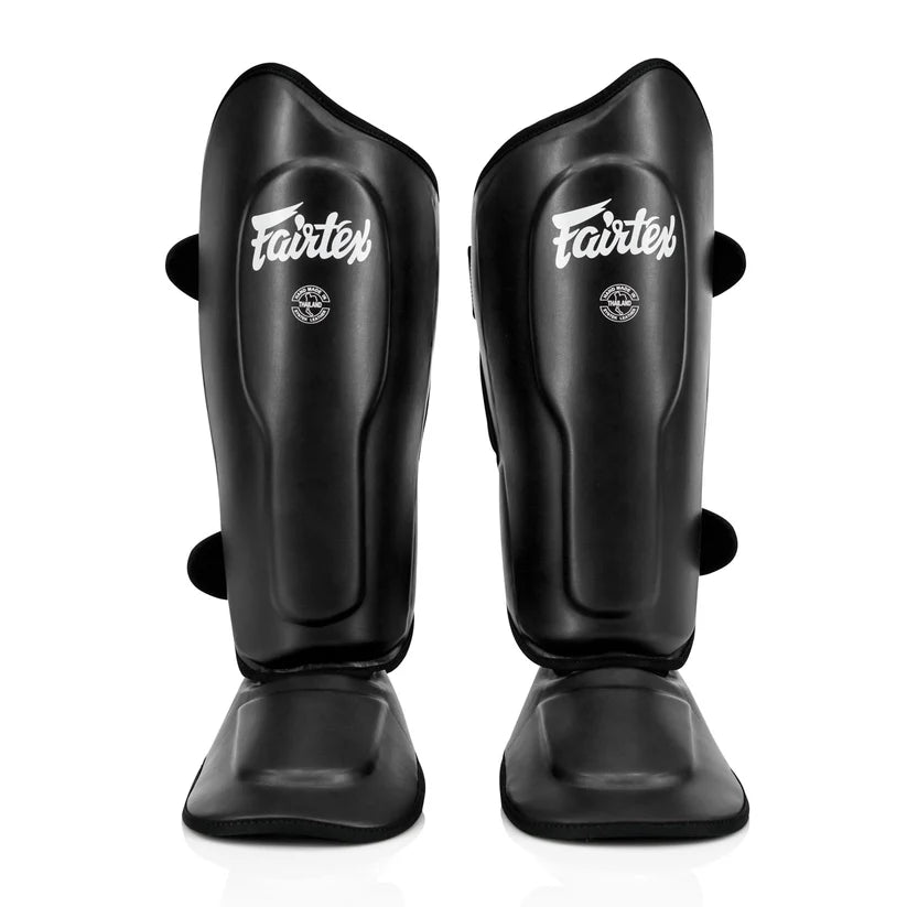 Fairtex shin guards for Muay Thai, MMA, and kickboxing with ergonomic open system design.