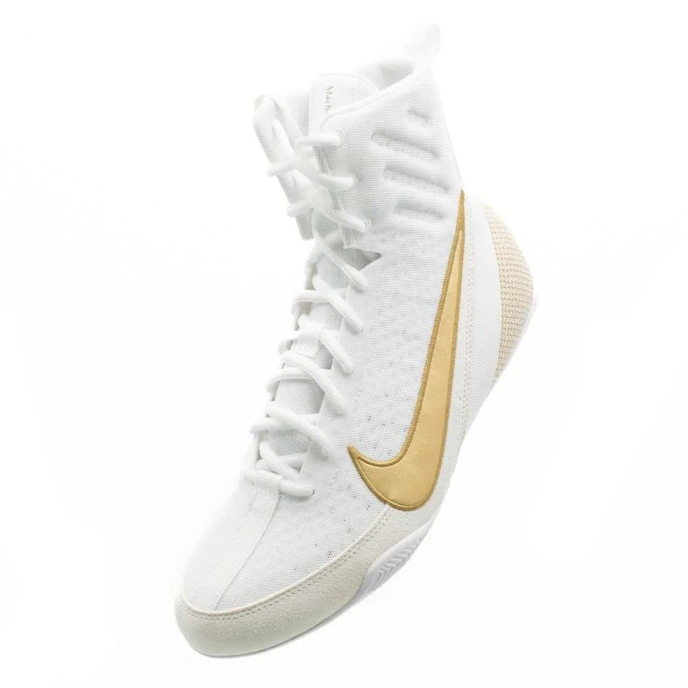 Boxer wearing Nike Machomai 3 white and gold boxing shoes during training session in the ring.