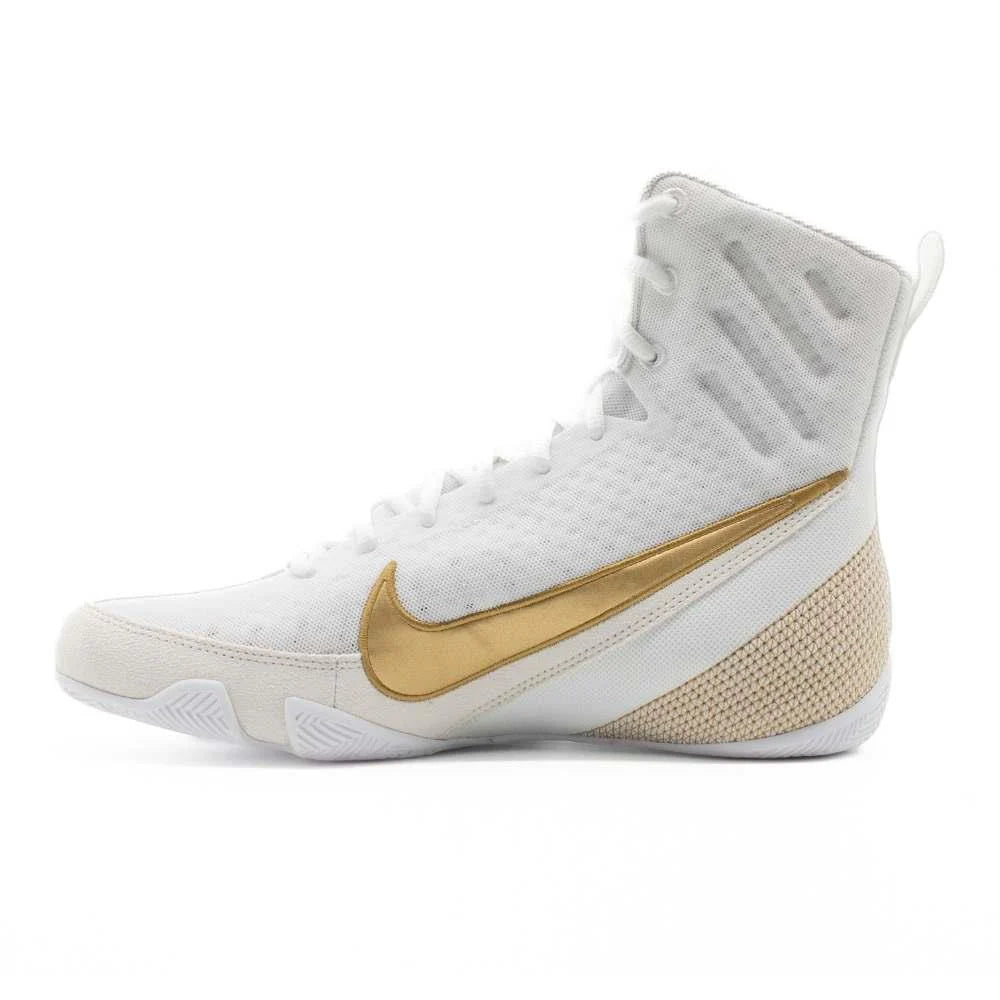 Side view of Nike Machomai 3 boxing boots showcasing sleek white and gold design with durable construction.