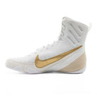 Side view of Nike Machomai 3 boxing boots showcasing sleek white and gold design with durable construction.