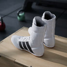 Model demonstrating a boxing pivot in adidas Box Hog Classic Cloud White/Core Black shoes