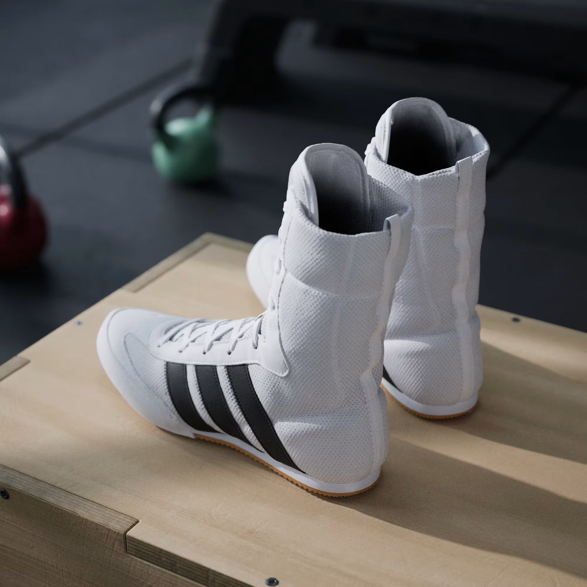 Model demonstrating a boxing pivot in adidas Box Hog Classic Cloud White/Core Black shoes
