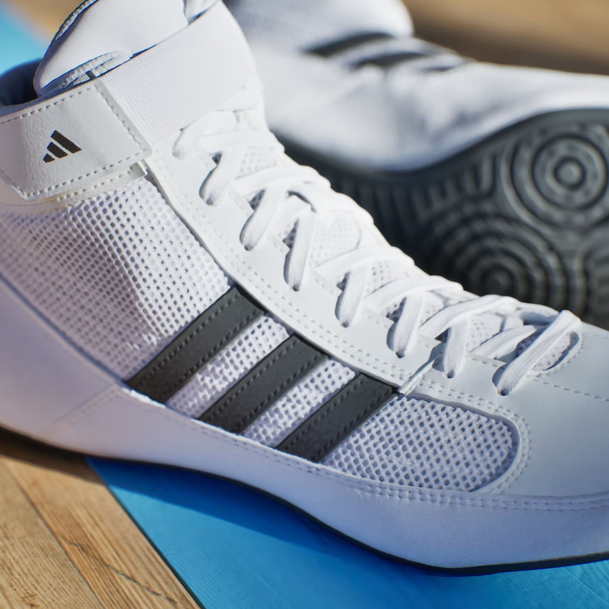 Adidas men’s wrestling shoes featuring lace closure with hook-and-loop strap for a secure fit during matches.