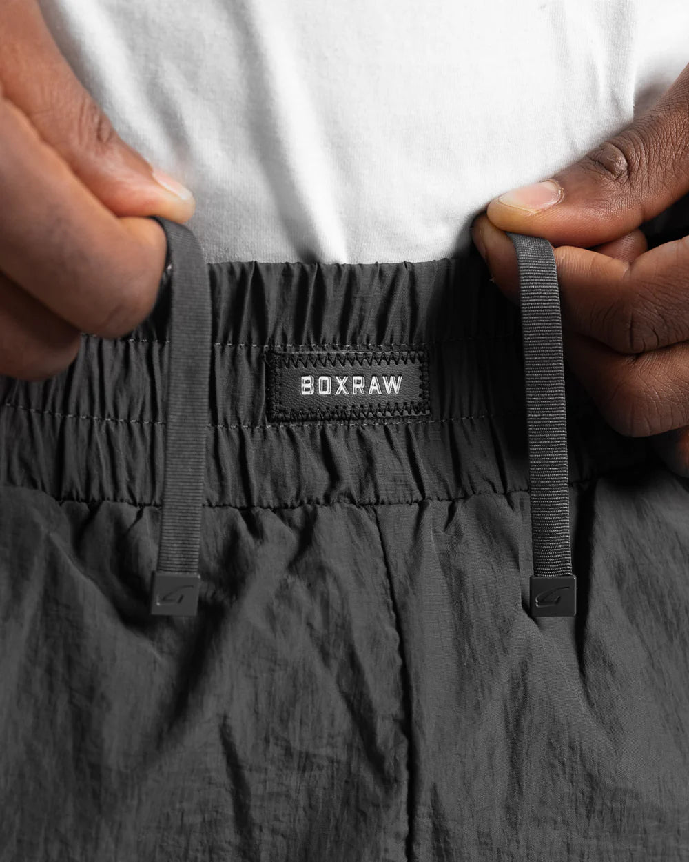 Elasticated waistband and metal drawstring ends close-up on Boxraw Tunero Track Bottoms Grey