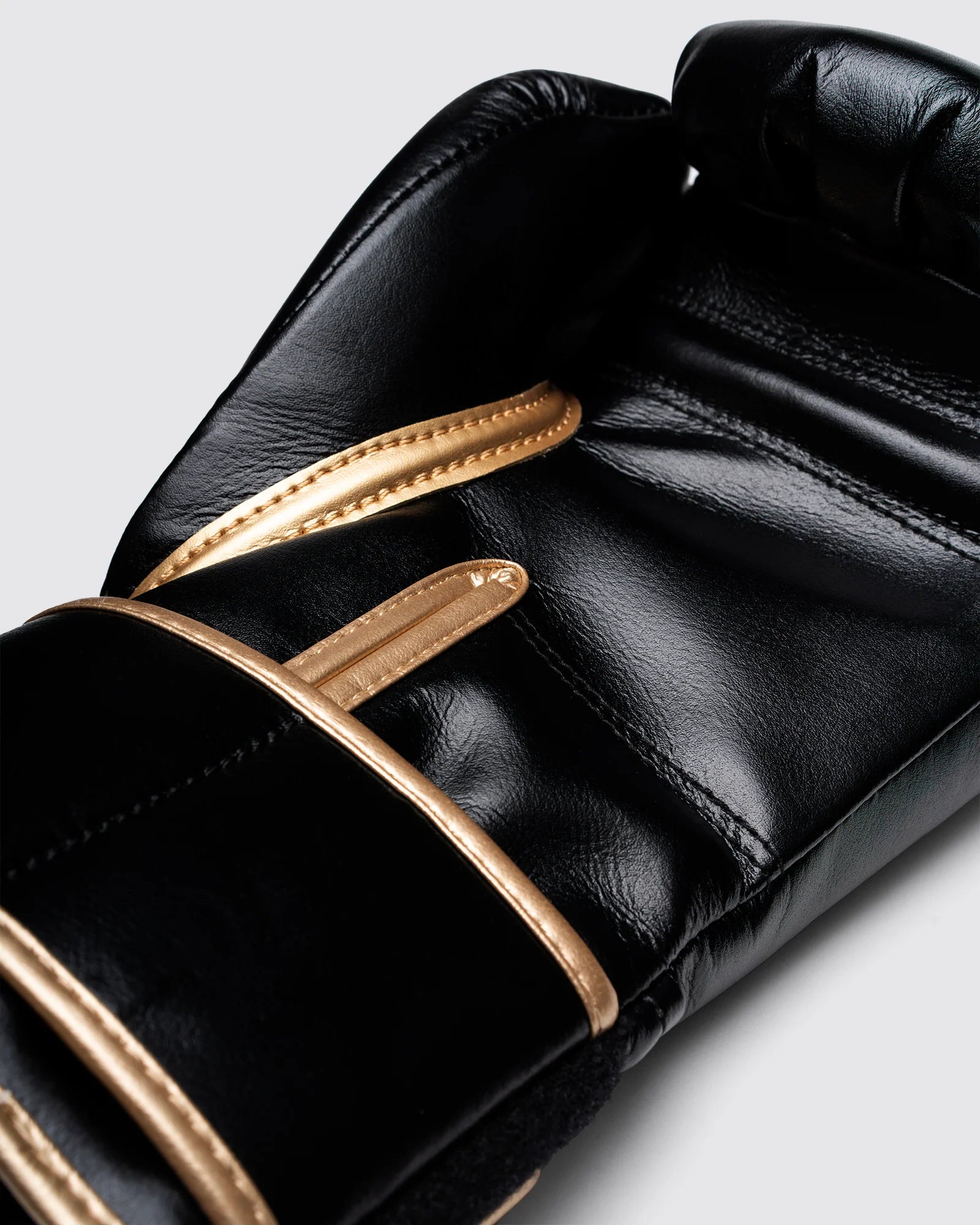 Athlete wearing Fly Superloop Pro X2 boxing gloves in black and gold during training session