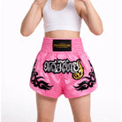 Side view of kids fuchsia pink Muay Thai shorts with tribal flame design and high side slit
