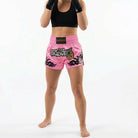 Side view of fuchsia pink Muay Thai shorts with tribal flame design and high side slit