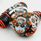 Twins Calaveras orange boxing gloves used in Muay Thai training session
