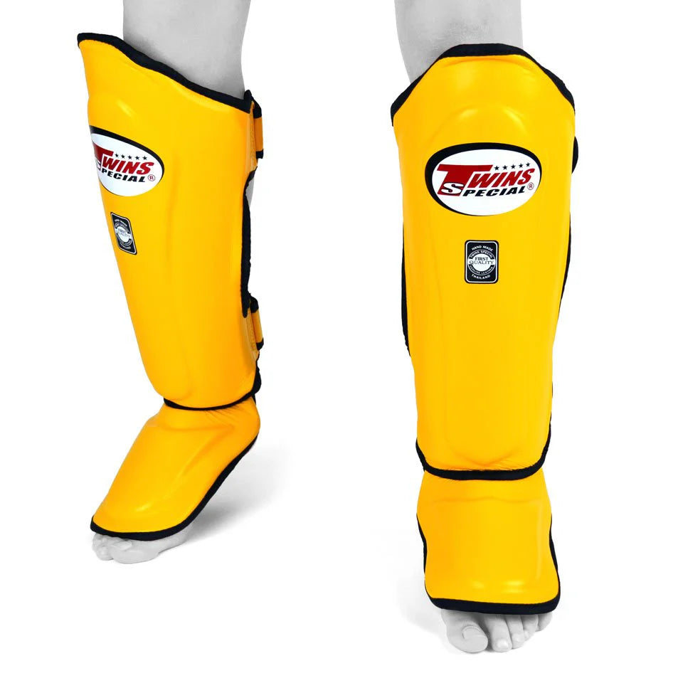 side profile of Twins yellow Muay Thai shin guards showing padding