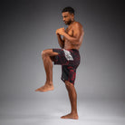 Side view of kicking Venum 20th Anniversary Fightshorts Black Red showing fight shorts profile