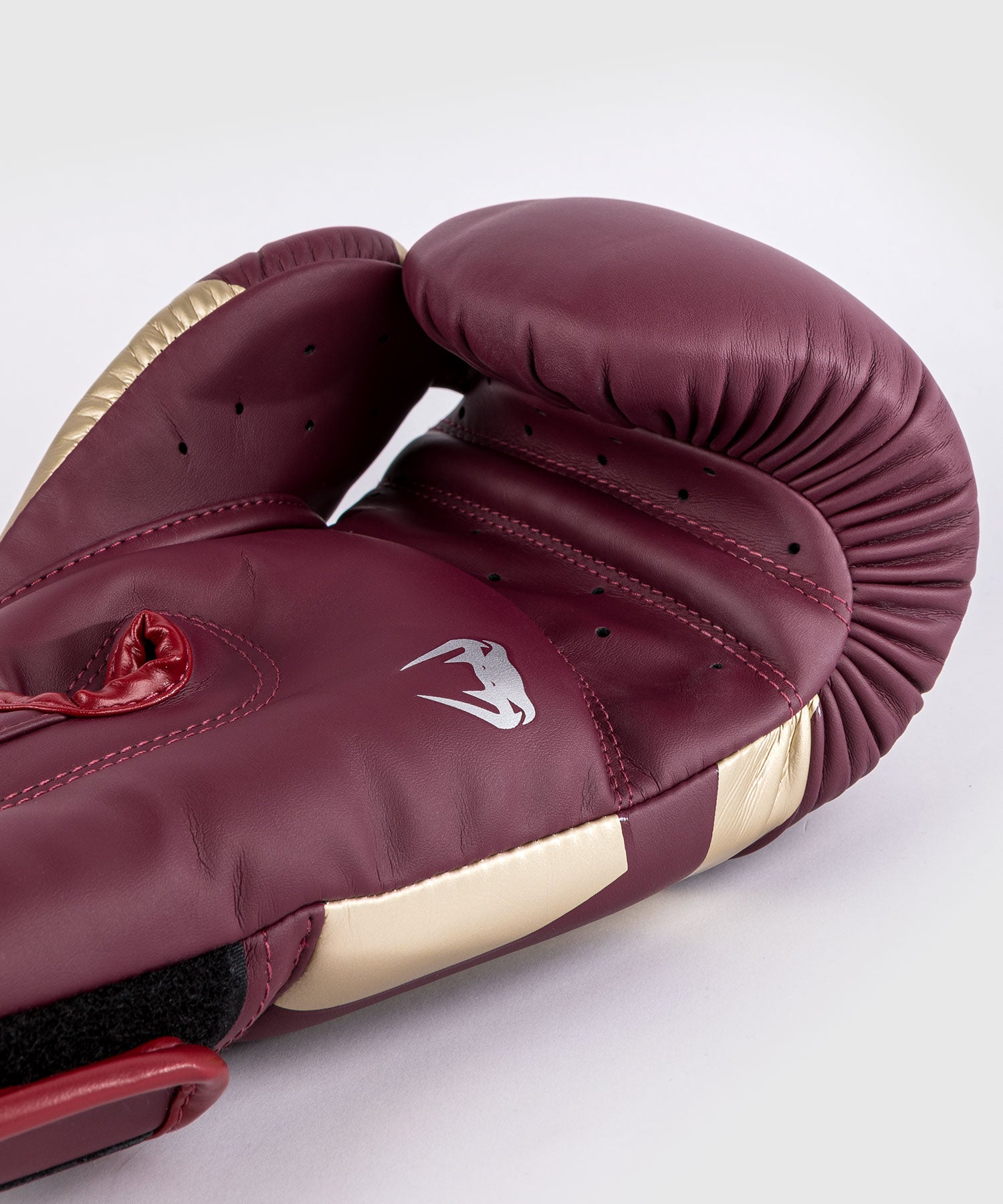 Close-up of Venum Elite Burgundy Gold boxing gloves Velcro wrist strap