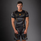 Venum Matupa Short Sleeve Rashguard Black Grey Gold front view showing tight compression rashguard design