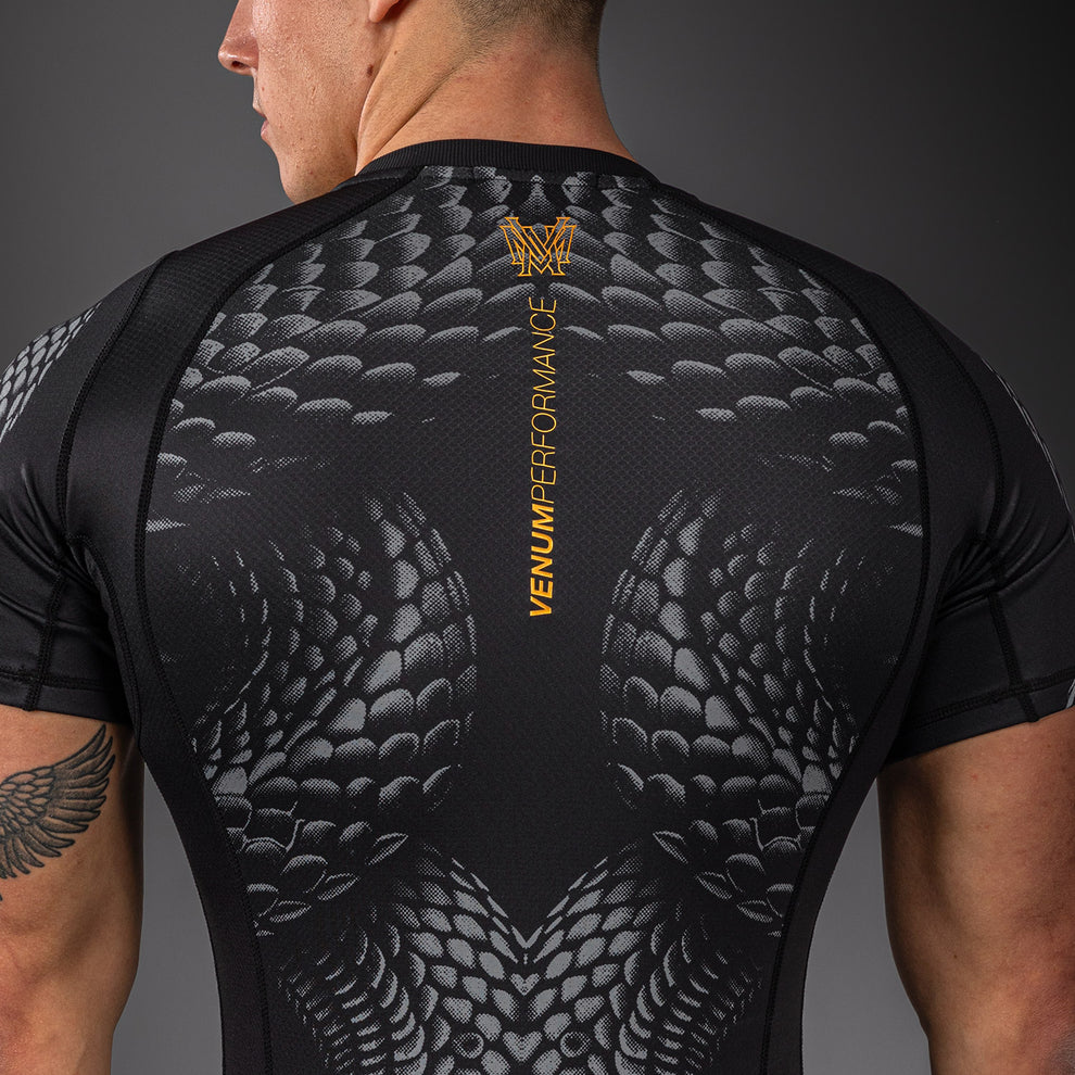 Sleeve and neckline detail close-up on Venum Matupa Short Sleeve Rashguard Black Grey Gold