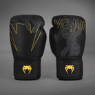 Front view of Venum Serpenti Boxing Gloves in Black/Silver/Gold with serpent graphics, Venum branding and gold wrist logos