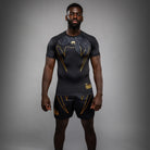 Venum Serpenti Short Sleeve Rashguard Black Silver Gold front view showing technical MMA rash guard design