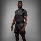 Side view of Venum Serpenti Short Sleeve Rashguard Black Silver Gold showing short sleeve compression fit