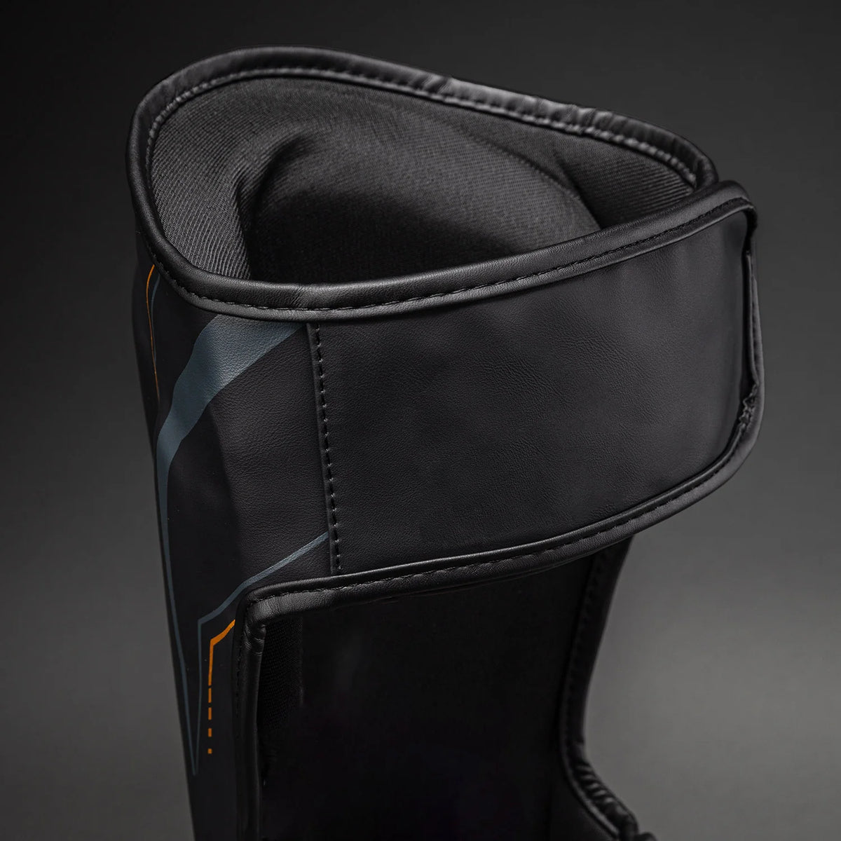 Black/Gold Venum Streamline Shin Guards showing the rear fastening area and adjustable support straps